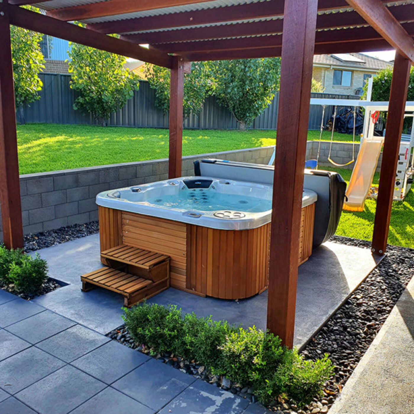 Backyard spa under a pergola, the type of spa that needs a compliant safety barrier